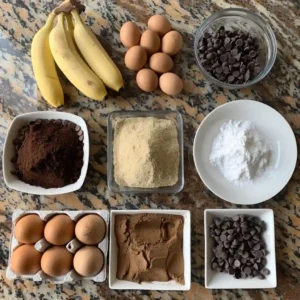All ingredients for protein brownies laid out on a wooden kitchen counter